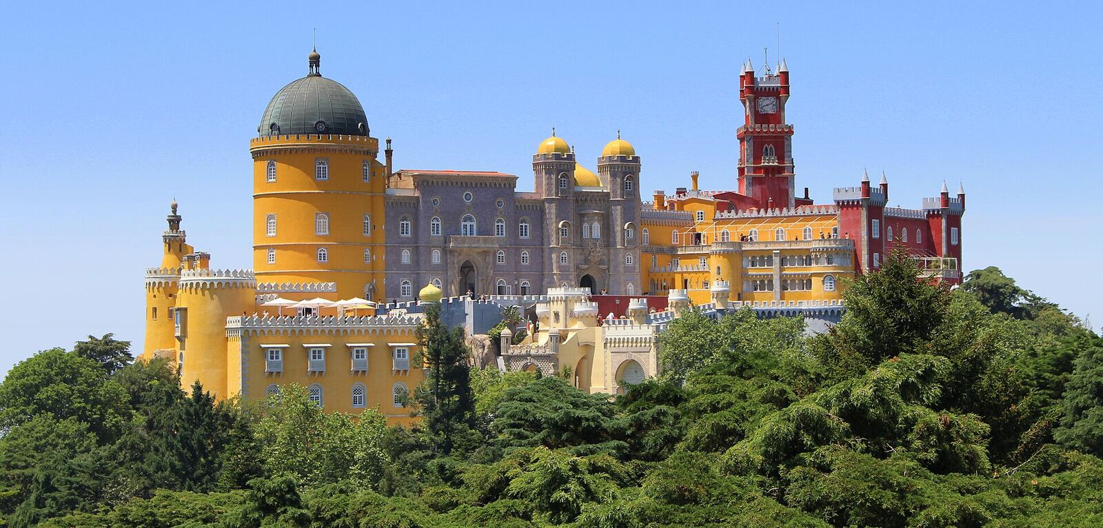 Pena Palace, with yellow and red towers, above the trees of the hills