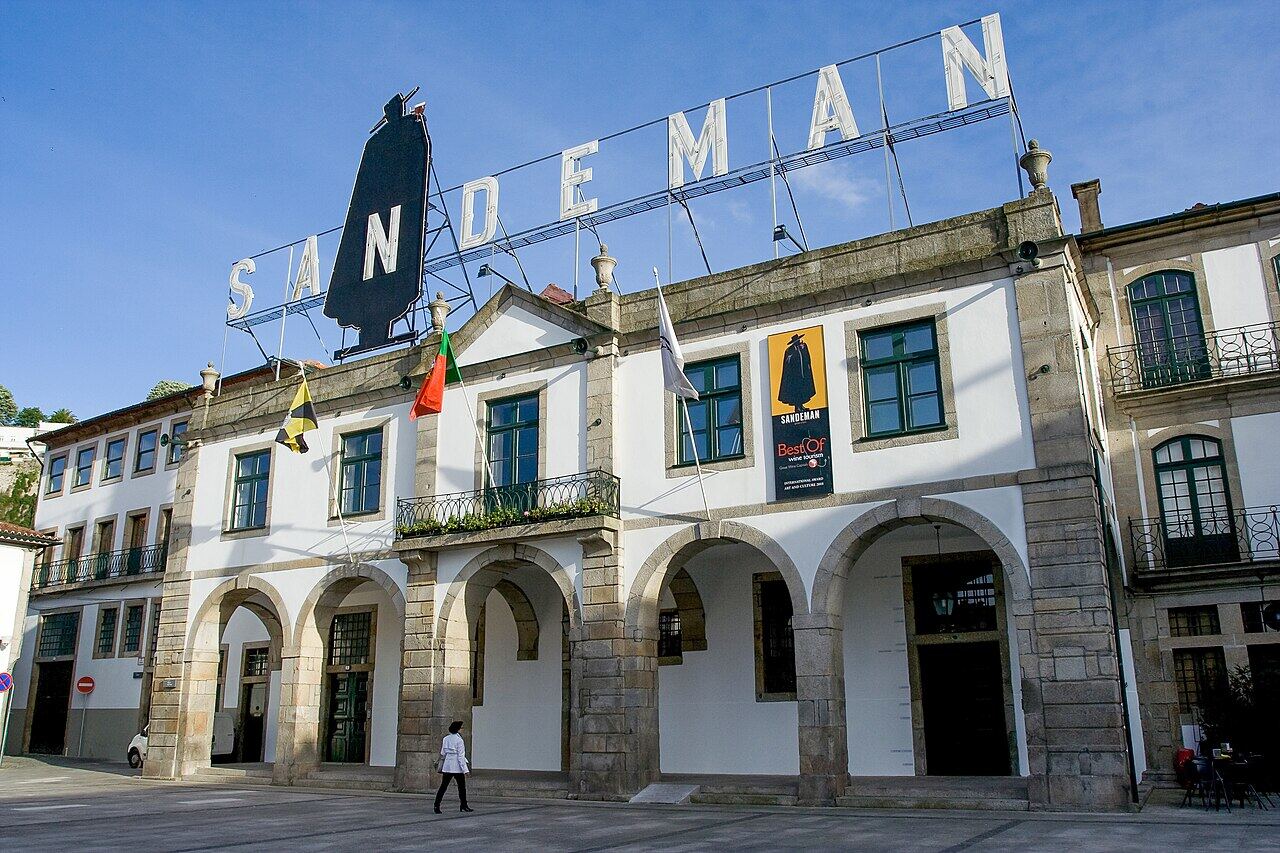 White building with arches and a port wine house sign on the roof